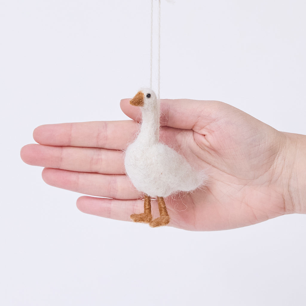 Craftspring’s Goose Ornament displayed in front of a hand to show its size — needle felted with fluffy feathers and beaded eyes, a sweet heirloom-quality piece perfect for Christmas gifting — ethically crafted by artisans using sustainable wool.