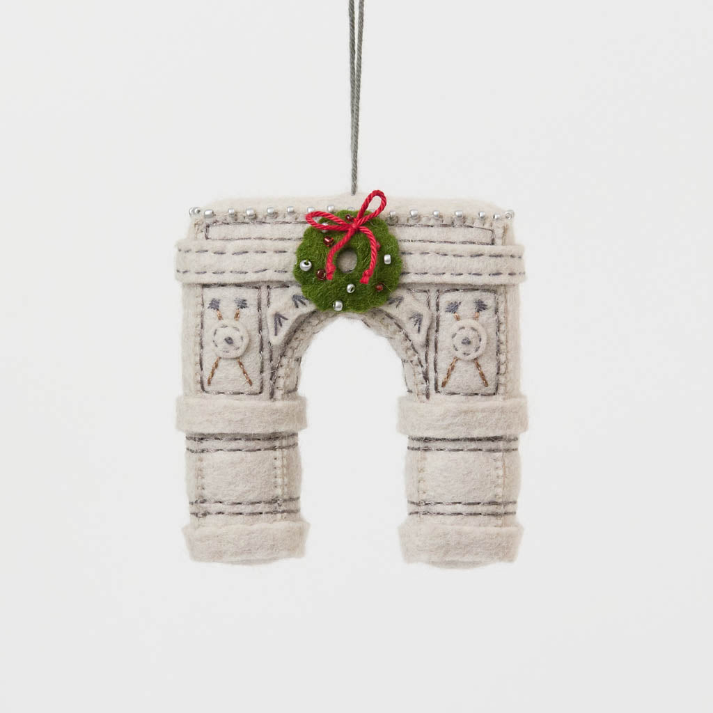  Our Grand Arch Ornament captures that timeless landmark, beautifully adorned with a festive holiday wreath for an extra touch of seasonal cheer.

Carefully handcrafted with embroidered architectural details, sculptural felt columns, delicate bead accents, and a miniature wreath tied with a bright red bow, this ornament celebrates both the elegance of the famous arch and the magic of Christmas in New York. 