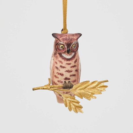 A vintage-inspired Great Horned Owl Resin Ornament, hand-painted in the Philippines and perched on a golden metal oak branch with sculpted leaves.