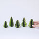 Craftspring’s Green Honeycomb Paper Mini Trees displayed in front of a hand to show scale — Set of 5 with several shades of green, gold sparkle on the edges, and varying shapes, handmade by artisans from recycled cotton waste.