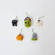 A handmade felt Halloween Mini Ornaments Set featuring five tiny spooky-season favorites: a black cat, candy-filled monster bucket, ghost, jack-o’-lantern, and RIP tombstone.