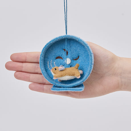 Craftspring’s Hamster on a Wheel ornament held in front of a hand to show its size—handmade from sustainable wool with cute embroidered details, ethically crafted by artisans using sustainable wool.