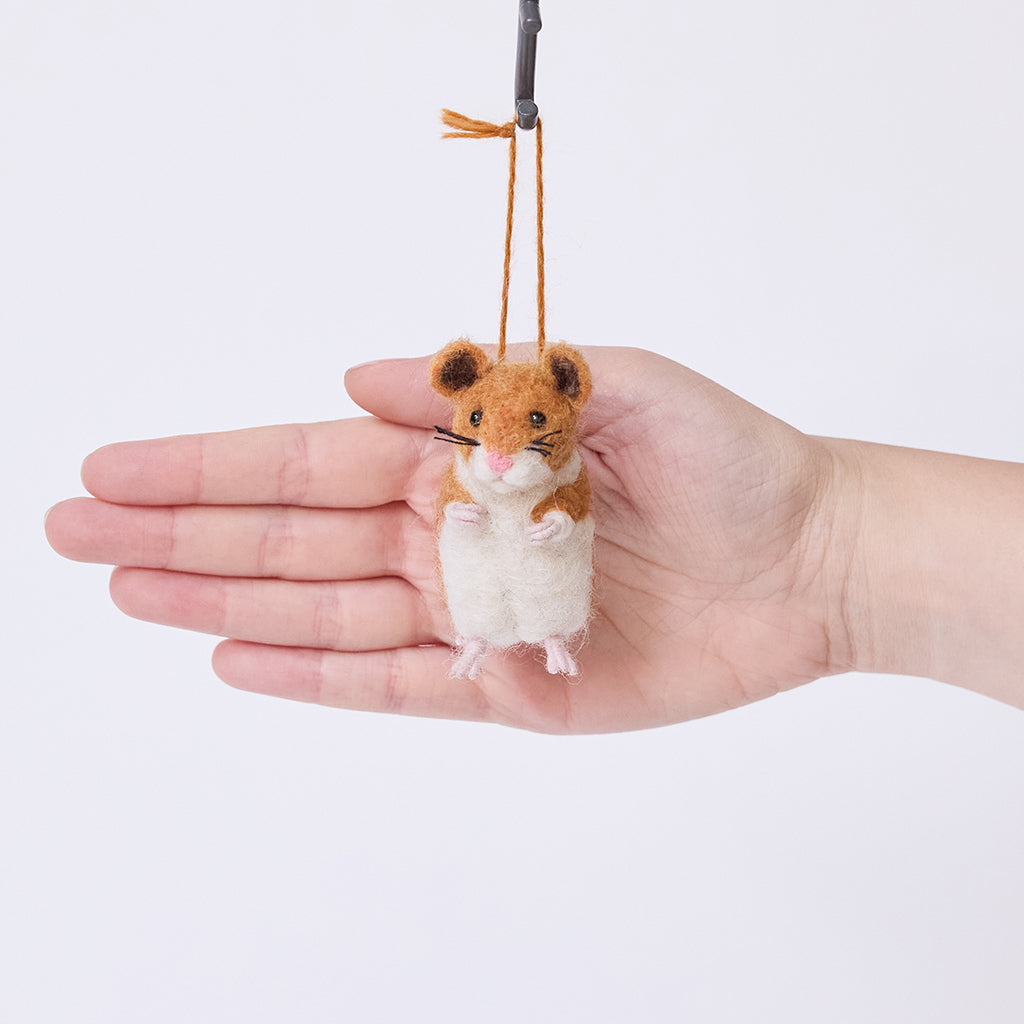 Craftspring’s Hamster ornament held in hand to show its size—needle-felted with whiskers and sweet little paws, ethically crafted by artisans using sustainable wool.