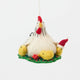 Gathered together on a festive green wreath our Holiday Hen with Chicks Ornament is a sweet celebration of family, nurturing, and holiday togetherness. A proud mother hen watches over her fluffy yellow chicks, while one festive little chick sports a tiny red Santa hat, adding an extra dash of Christmas cheer. 