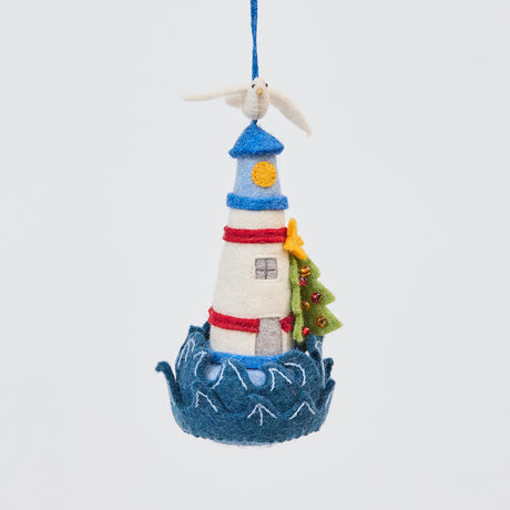 Handmade felt Holiday Lighthouse Christmas ornament from Craftspring, featuring a seagull on top, crashing waves, and a Christmas tree—adorned with intricate beaded and embroidered details, heirloom-quality holiday decor, ethically crafted by artisans using sustainable wool.
