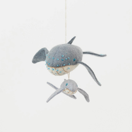Graceful, gentle, and full of wonder, our Humpback Whale with Baby Ornament captures one of nature’s most touching sights—a mother whale guiding her calf through the open sea. Handcrafted from soft felted wool and accented with shimmering blue beadwork, this beautiful ornament celebrates the deep connection between parent and child while honoring the majestic marine life that frequents Maine’s coastal waters.