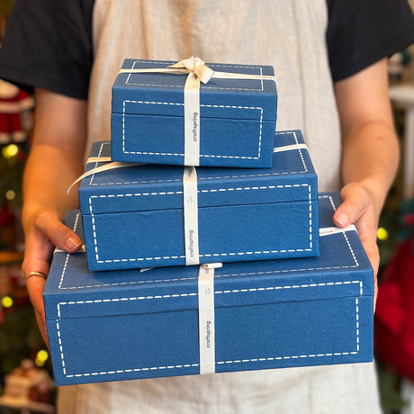 All three sizes of Craftspring’s blue gift boxes wrapped with twill ribbon, held in hand—celebrating thoughtful, artisan-crafted holiday gifting with heirloom-quality packaging.