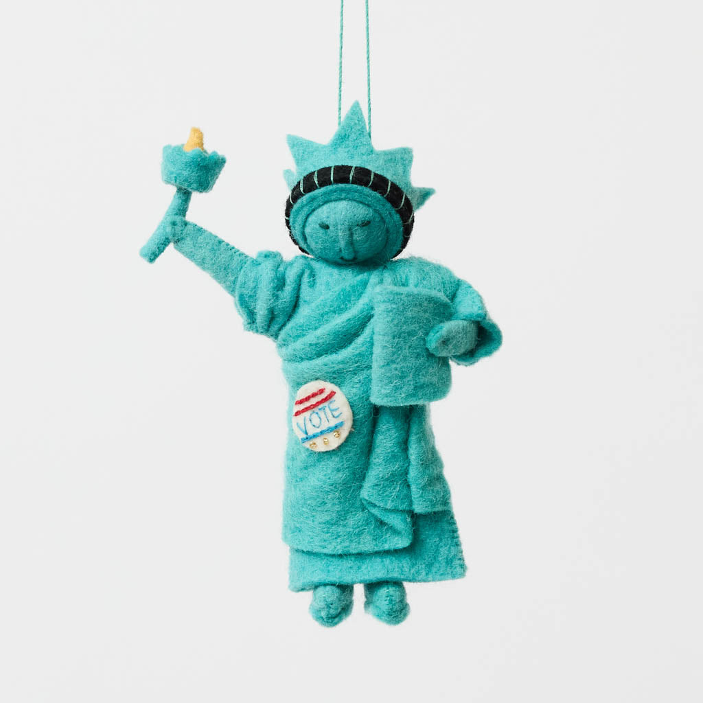 Celebrate the power of democracy with our handcrafted&nbsp;I Voted Lady Liberty Ornament from the Craftspring Semiquincentennial Collection. Inspired by the iconic Statue of Liberty, this felt ornament features Lady Liberty holding her torch and tablet while proudly displaying an “I Voted” badge—symbolizing freedom, participation, and the enduring values of American democracy.