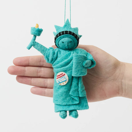 Celebrate the power of democracy with our handcrafted&nbsp;I Voted Lady Liberty Ornament from the Craftspring Semiquincentennial Collection. Inspired by the iconic Statue of Liberty, this felt ornament features Lady Liberty holding her torch and tablet while proudly displaying an “I Voted” badge—symbolizing freedom, participation, and the enduring values of American democracy.