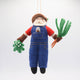 Felt Santa ornament in garden overalls holding a carrot—handcrafted for nature-themed Christmas trees