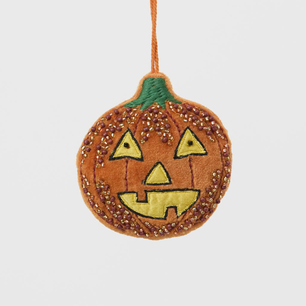 A vintage-inspired handmade beaded Jack O’Lantern Ornament featuring a smiling embroidered pumpkin face on one side and festive “Trick or Treat” detailing on the reverse.