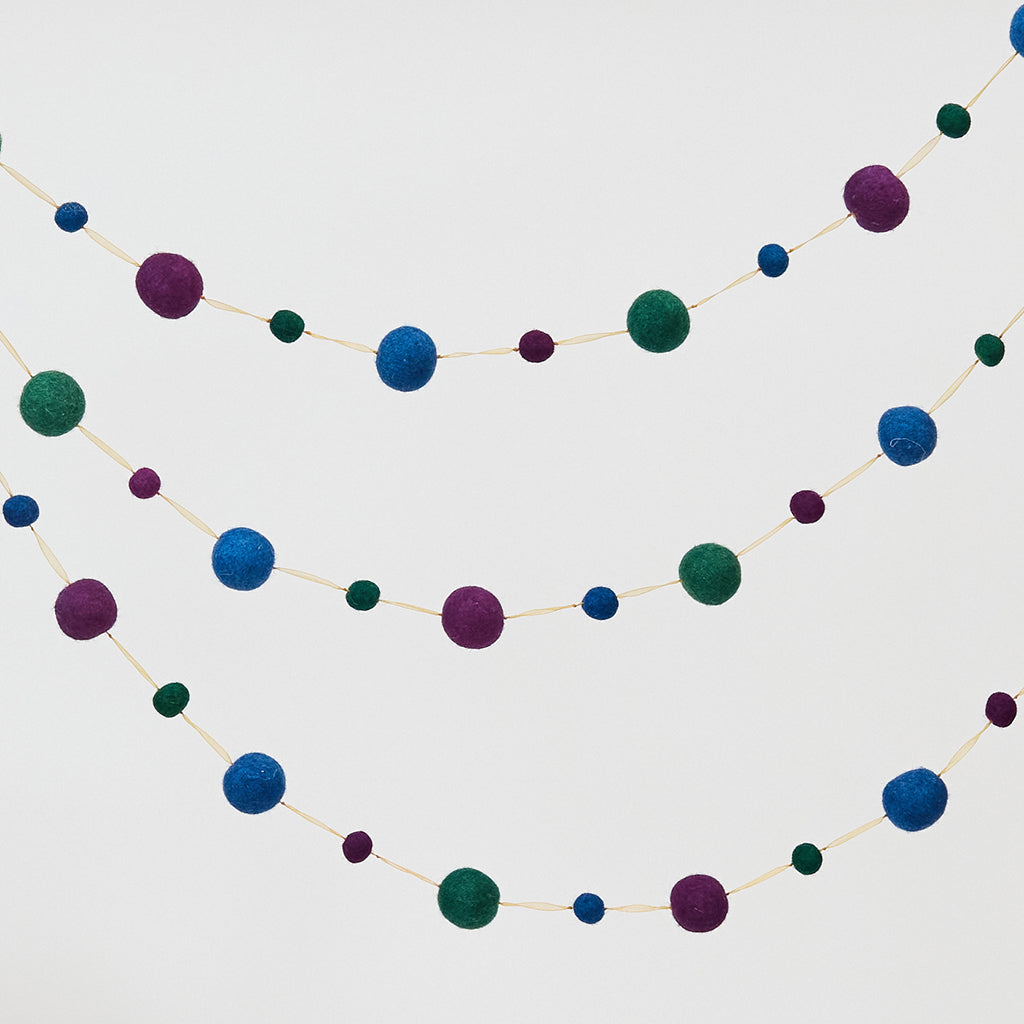 Handmade felt Jewel Tone Ball Garland from Craftspring, featuring deep jewel-tone felt balls strung on a gold ribbon—heirloom-quality holiday decor perfect for adding rich, festive color, ethically crafted by artisans using sustainable wool.