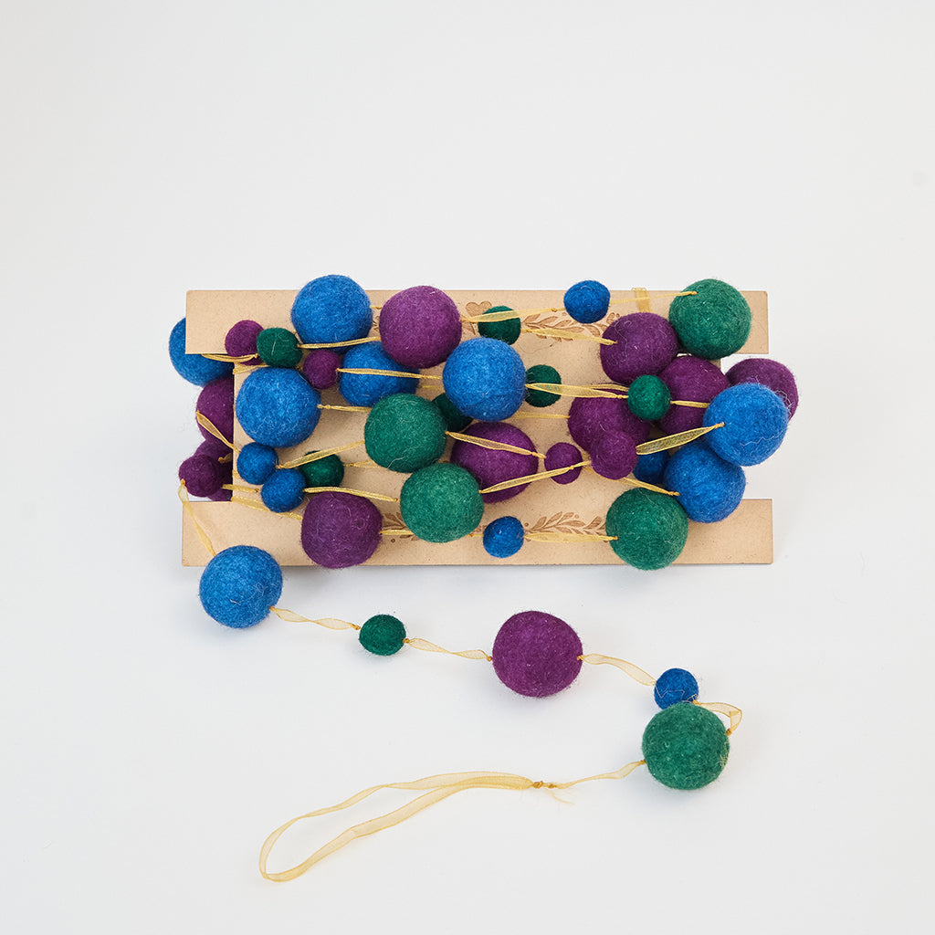 Handmade felt Jewel Tone Ball Garland from Craftspring, featuring deep jewel-tone felt balls strung on a gold ribbon—heirloom-quality holiday decor perfect for adding rich, festive color, ethically crafted by artisans using sustainable wool.