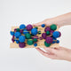 Handmade felt Jewel Tone Ball Garland from Craftspring held in hand to show size—featuring deep jewel-tone felt balls strung on a gold ribbon, showcasing heirloom-quality holiday decor, ethically crafted by artisans using sustainable wool.