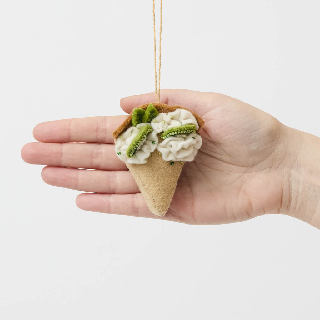 Capture the sweet taste of the Florida Keys with our handcrafted Key Lime Pie Slice Felt Ornament, a delightful dessert-inspired decoration featuring fluffy whipped cream, vibrant lime accents, and realistic pie slice details. Handmade from sustainable wool felt by women artisans, this whimsical ornament celebrates one of America's most beloved tropical desserts and adds a playful touch to holiday décor.