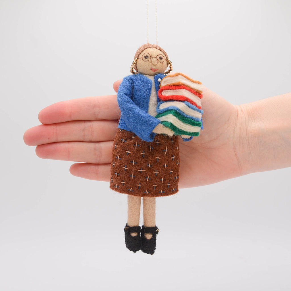 Felt librarian figure ornament, lovingly handmade for bookworms, writers, and those who find joy in every chapter. A hand to show scale.