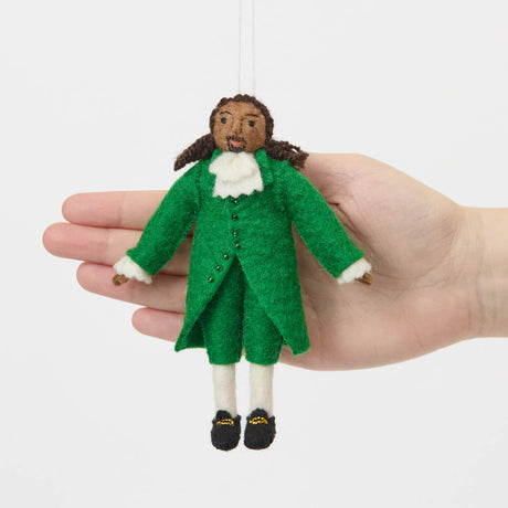 Celebrate the cultural phenomenon that brought Revolutionary history to a new generation with our handcrafted Lin-Manuel Miranda as Hamilton Ornament. Inspired by his iconic portrayal of Alexander Hamilton, this felt ornament captures the energy, creativity, and theatrical spirit of a groundbreaking American story.