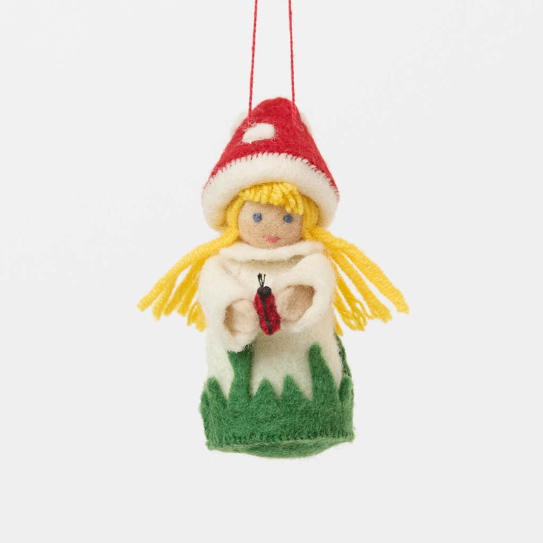 A magical little child of the forest, bringing good fortune, woodland wonder, and a sprinkle of fairy-tale enchantment into your home all year round! This sweet little red Amanita mushroom girl ornaments features a bright red felted mushroom cap, dotted with delicate white spots, and a skirt hemmed with felted green grasses. 