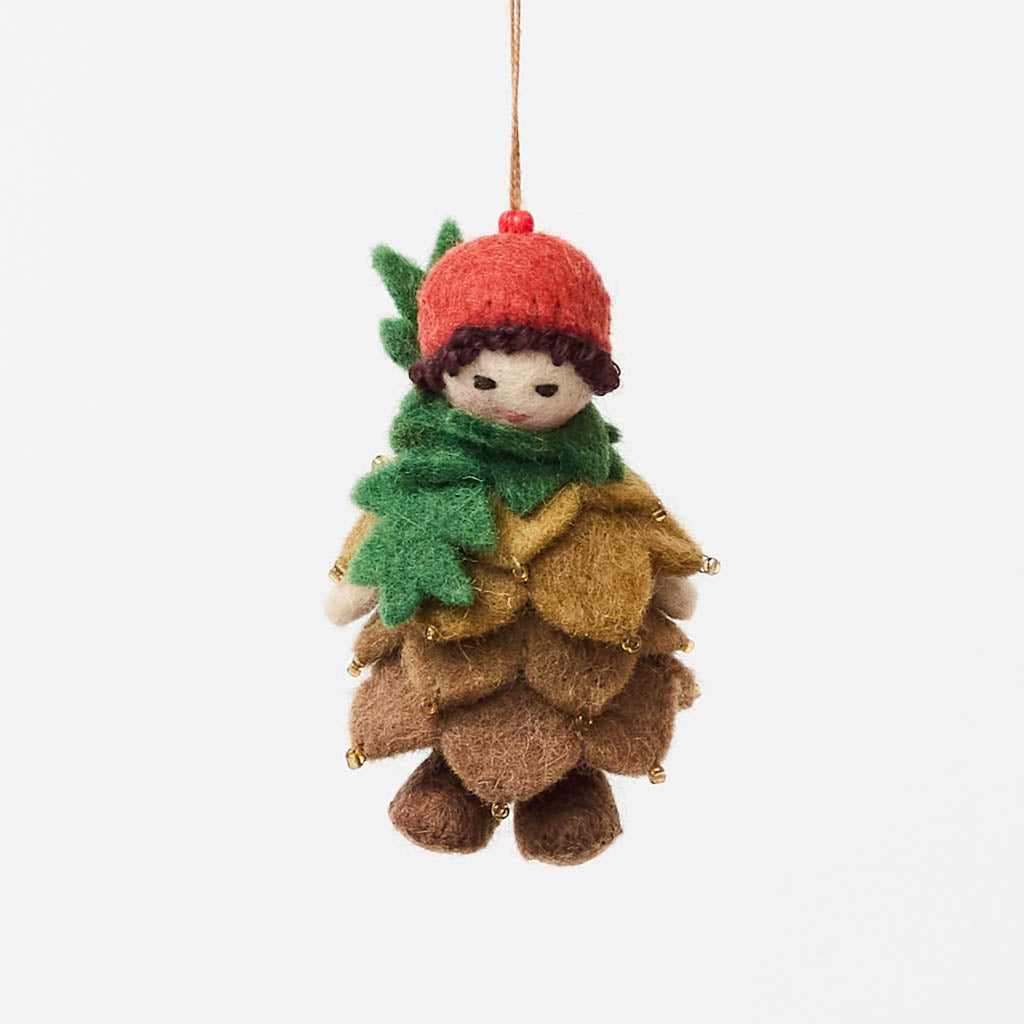 Waldorf-inspired, our Little Pinecone Kid Ornament captures the whimsical spirit of a woodland fairy tale. With its cute woolen bonnet, it's pine-green scarf and lovely layered pinecone petals and sweet as can be felted booties - this pinecone child is ready to capture woodland hearts.
