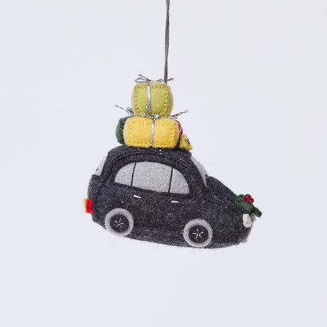 Handmade felt London Black Cab ornament from Craftspring, featuring beaded and embroidered details with festive presents on top of the car and holly accents—heirloom-quality Christmas decor, ethically crafted by artisans using sustainable wool.