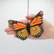Handmade felt monarch butterfly ornament with embroidered details and beading in orange and black