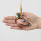A vintage-inspired Mallard Duck Resin Ornament, hand-painted in the Philippines with a golden metal holly necklace and satin hanging ribbon.
