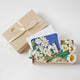 Merci Gift Box Set featuring a felt blueberry ornament, white daisy flower bouquet in vase, and daisy greeting card. Handmade from wool felt with French-inspired floral charm. Fair trade and ready to gift.