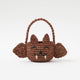 A hand-crocheted raffia Mini Bat Basket featuring playful wings, pointed ears, tiny fangs, and a sweet embroidered face for Halloween treats, treasures, and imaginative play.