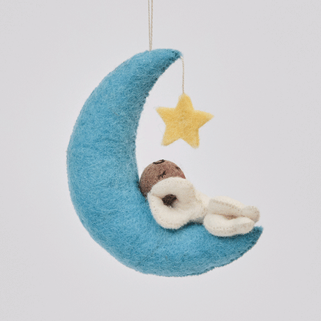 Handmade felt Moon Dreamer Baby Ornament – Brown from Craftspring rotating to show front, side, and back views—featuring a sleeping baby with brown skin on a crescent moon with a dangling star, with delicate embroidered details highlighting its heirloom quality, ethically crafted by artisans using sustainable wool.