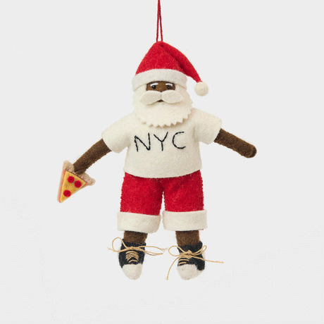 Celebrate Christmas in the Big Apple with our handmade NYC Santa Ornament, featuring a deep brown Santa dressed like a true New Yorker in an NYC tee and sneakers, with a classic slice of New York pizza in hand.
