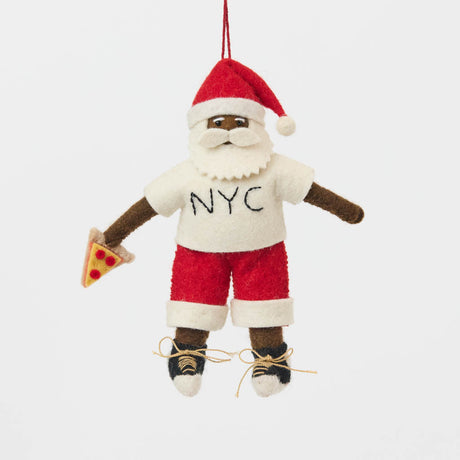 Celebrate Christmas in the Big Apple with our handmade NYC Santa Ornament, featuring a deep brown Santa dressed like a true New Yorker in an NYC tee and sneakers, with a classic slice of New York pizza in hand.