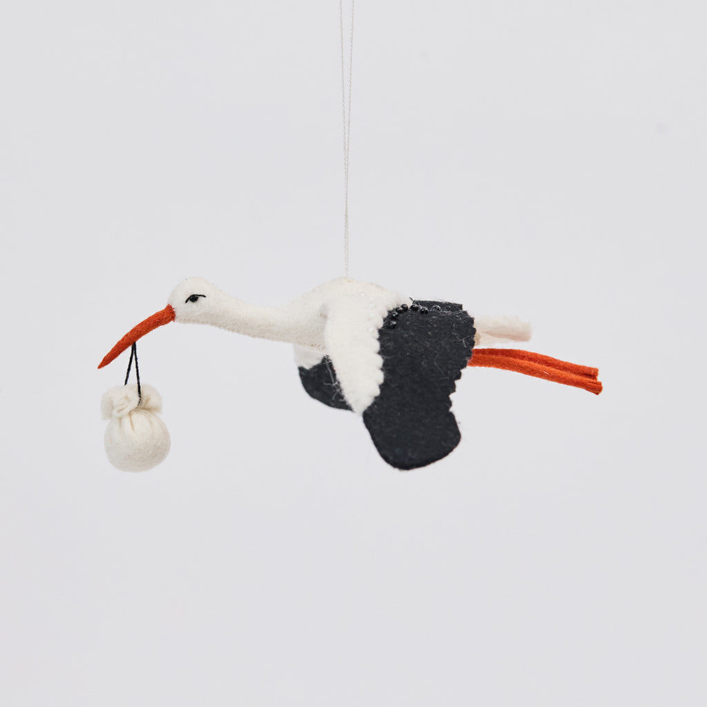 Handmade felt New Baby Stork ornament from Craftspring, featuring a stork carrying a bundle with intricate beaded and embroidered details—showcasing artisan craftsmanship and heirloom-quality design, ethically crafted using sustainable wool.