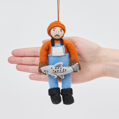 Craftspring’s Old Man Salmon ornament held in front of a hand to show its size—charming Christmas decor, ethically handmade from sustainable wool with embroidered details.