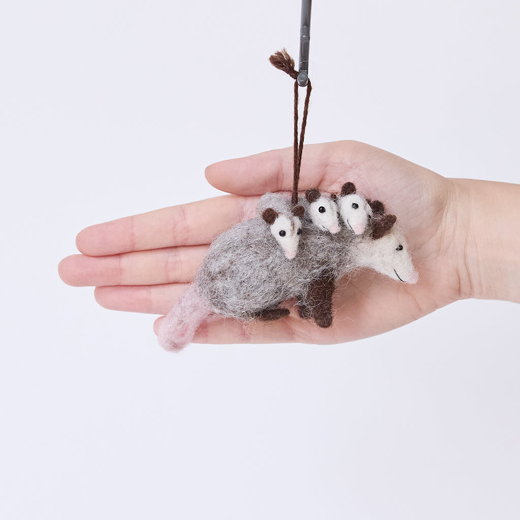 Craftspring’s Opossum Mom with Babies Ornament displayed in front of a hand to show its size — featuring three babies with cute faces and pink tails, a sweet heirloom-quality piece perfect for Christmas gifting — ethically crafted by artisans using sustainable wool.