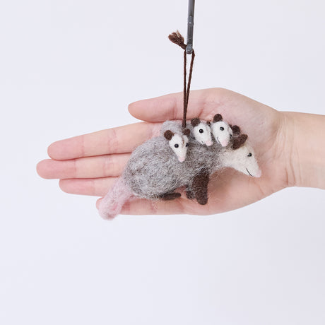 Craftspring’s Opossum Mom with Babies Ornament displayed in front of a hand to show its size — featuring three babies with cute faces and pink tails, a sweet heirloom-quality piece perfect for Christmas gifting — ethically crafted by artisans using sustainable wool.