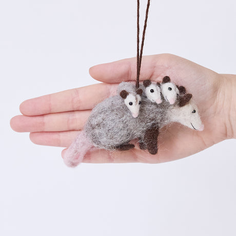 Craftspring’s Opossum Mom with Babies Ornament displayed in front of a hand to show its size — featuring three babies with cute faces and pink tails, a sweet heirloom-quality piece perfect for Christmas gifting — ethically crafted by artisans using sustainable wool.