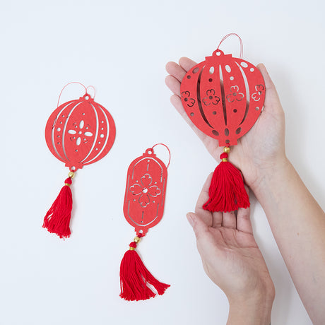 Craftspring’s Paper Lantern Ornaments held in hand to show their size, highlighting the intricate paper cutout designs made for Lunar New Year gifting and decor.