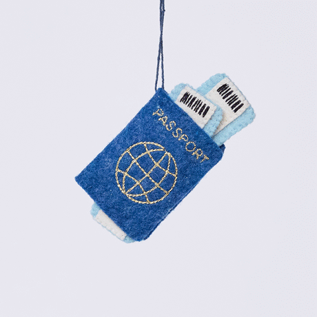 Handmade felt Passport ornament from Craftspring rotating to show front, side, and back views—featuring applique and embroidered details with two plane tickets tucked inside and passport stamps on the back, ethically crafted by artisans using sustainable wool.