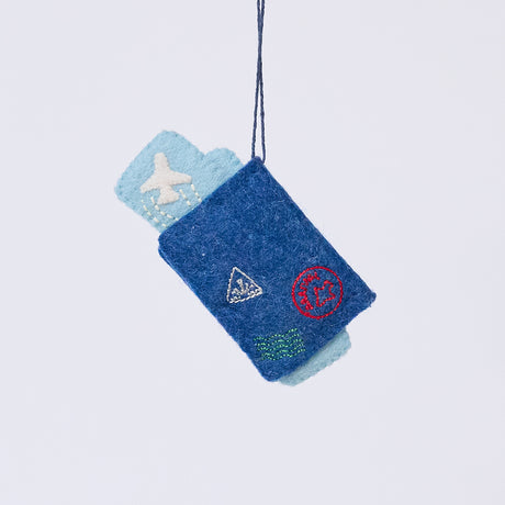 Handmade felt Passport ornament from Craftspring, featuring applique and embroidered details with two plane tickets tucked inside and passport stamps on the back—heirloom-quality Christmas decor, ethically crafted by artisans using sustainable wool.