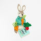 Handmade wool ornament of Peter Rabbit, featuring the beloved children's book character sitting with a carrot in one paw and an embroidered book on his lap. He wears his signature blue jacket, crafted with detailed stitching. Made from natural felted merino-blend wool, the ornament is ready to hang and sized approximately 4.5 inches tall.