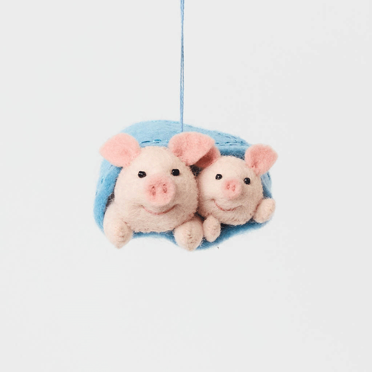 Cozy, cuddly, and completely irresistible—our Pigs in a Blanket Ornament is here to wrap your holidays in pure joy. Featuring a sweet pig parent and baby snuggled snugly inside a soft blue “blanket,” this playful design brings together comfort, humor, and heartfelt connection in the most delightful way.
