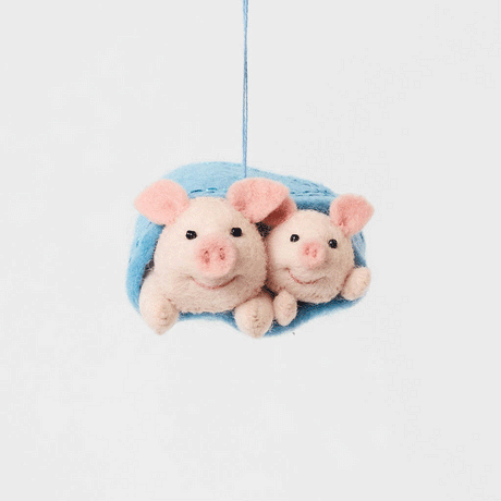 Cozy, cuddly, and completely irresistible—our Pigs in a Blanket Ornament is here to wrap your holidays in pure joy. Featuring a sweet pig parent and baby snuggled snugly inside a soft blue “blanket,” this playful design brings together comfort, humor, and heartfelt connection in the most delightful way.