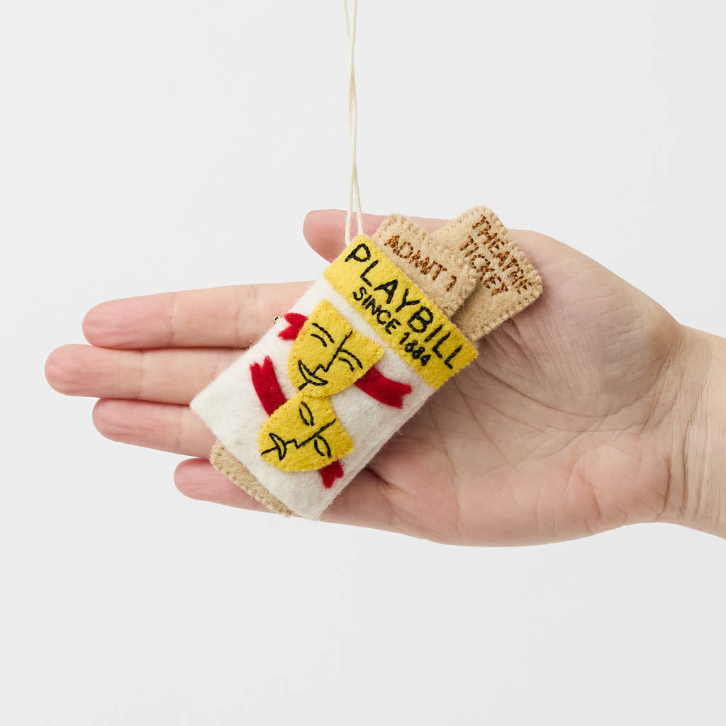 Celebrate the magic of Broadway with our handmade Playbill Ornament, inspired by the iconic theater program and finished with a hidden "Bravo!" message to honor every unforgettable performance.