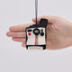 Handmade felt Polaroid Camera ornament from Craftspring held in front of a hand to show its size—featuring detailed stitching and a charming retro design, perfect for gifting and sparking nostalgia, ethically crafted by artisans in India using sustainable wool.