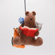 Handmade felt ornament featuring a cozy scene with a bear reading a book, surrounded by woodland friends. Crafted from eco-friendly wool, this ornament captures the magic of shared reading and childhood adventures. A heartwarming gift for book-loving families, young readers, and those who cherish the joy of storytelling. Ready to hang with a string attached, it adds a whimsical touch to holiday trees and reading spaces.