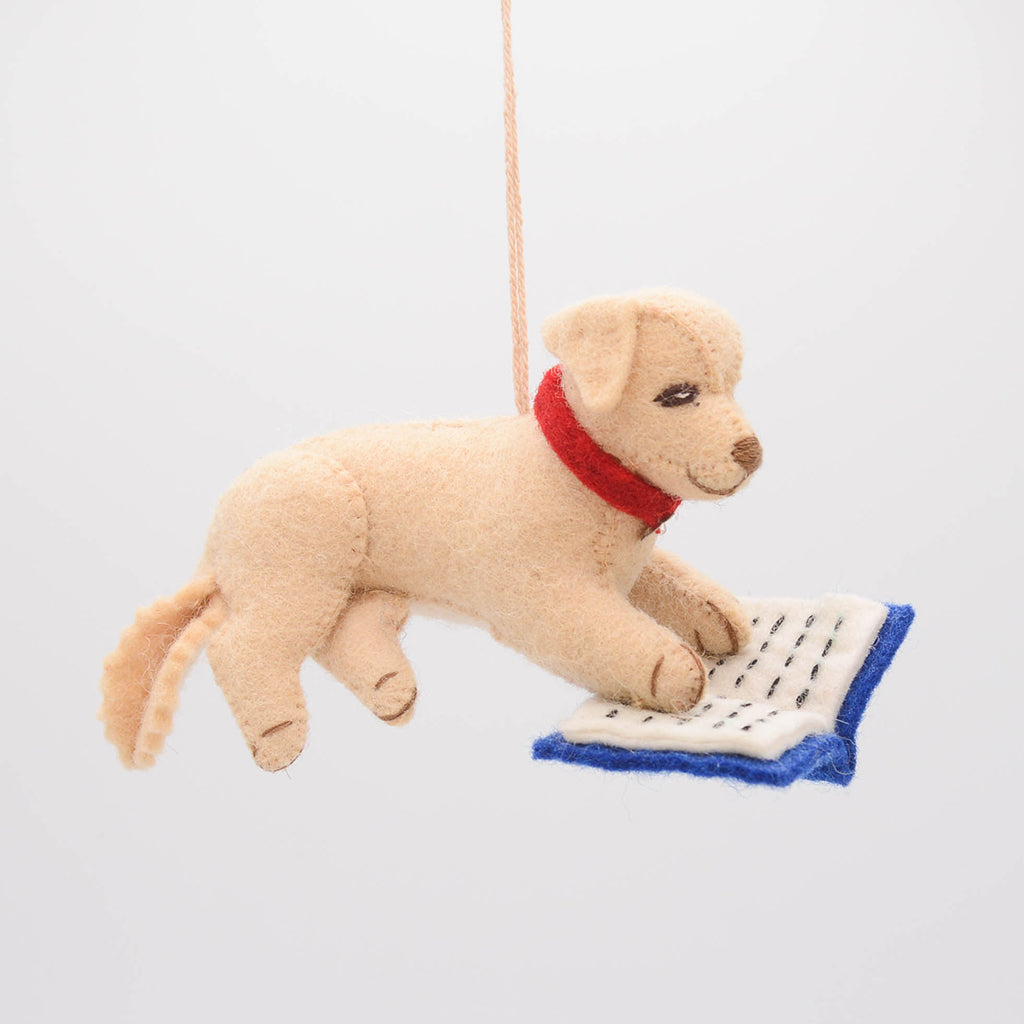 Whimsical reading dog ornament crafted from natural wool – perfect for celebrating the quiet joy of reading and story time rituals.