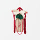 Our Red Flyer Sled Ornament captures the nostalgia of childhood winters and treasured holiday traditions. Inspired by classic wooden sleds, this charming keepsake features bright red runners, a cozy neutral-toned seat embroidered with "Flyer," and a festive holly sprig nestled beneath a soft white bow.