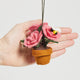 Eco-friendly felt ornament of a rose bouquet in a soft wool pot with tiny embroidered bees, symbolizing the joy of gardening year-round