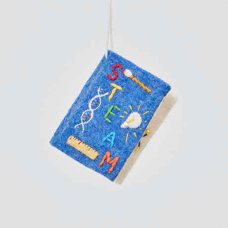 Handmade felt STEAM Book ornament from Craftspring spinning to show front, side, and back covers—featuring embroidered details of DNA strand, paintbrush, light bulb, and ruler, ethically crafted by artisans using sustainable wool.