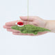 Craftspring’s Santa Alligator Ornament displayed in front of hand to show its size — felt alligator with a beautiful face and embroidered and beaded back ridges, a charming heirloom-quality piece for Christmas gifting — ethically crafted by artisans using sustainable wool.
